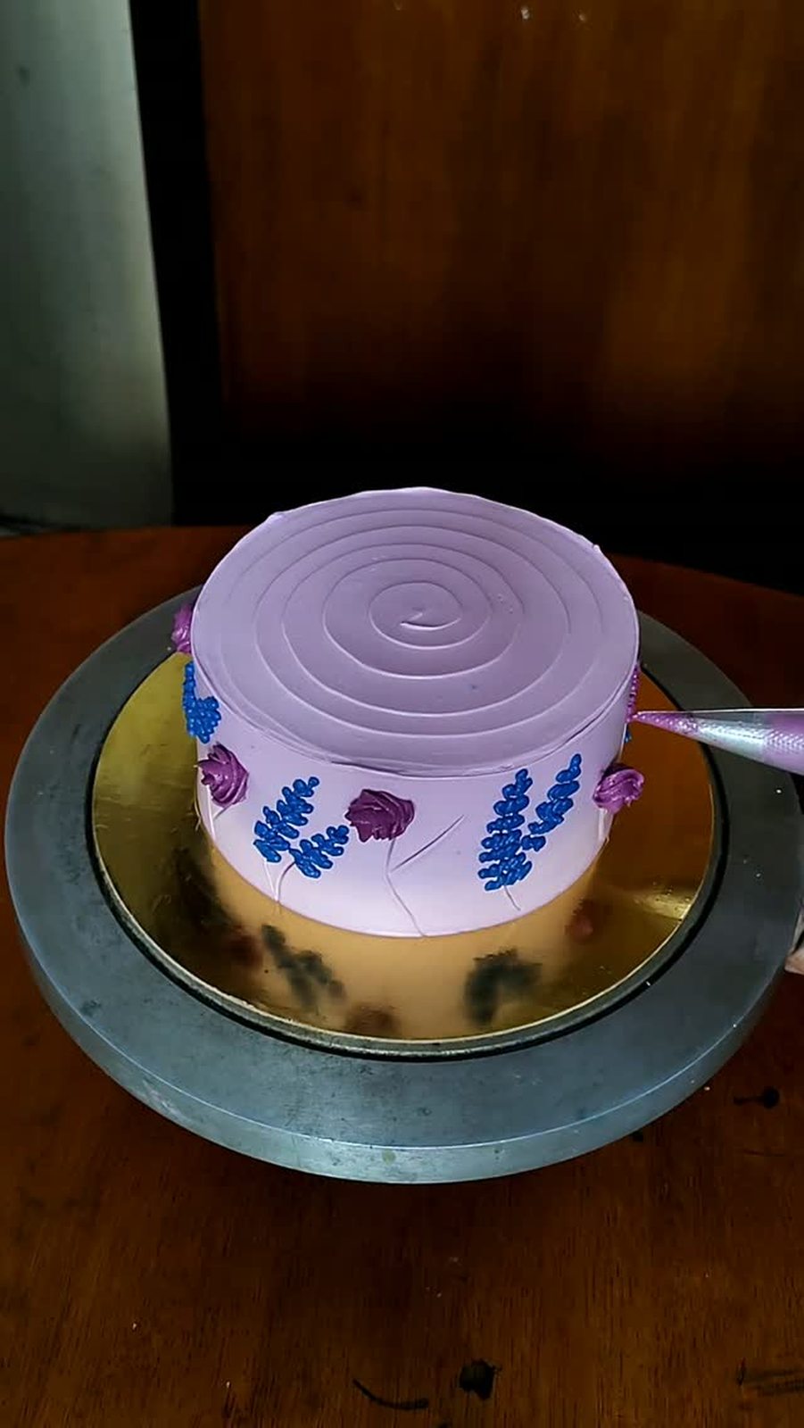 Lavender sprigs being piped on a cake