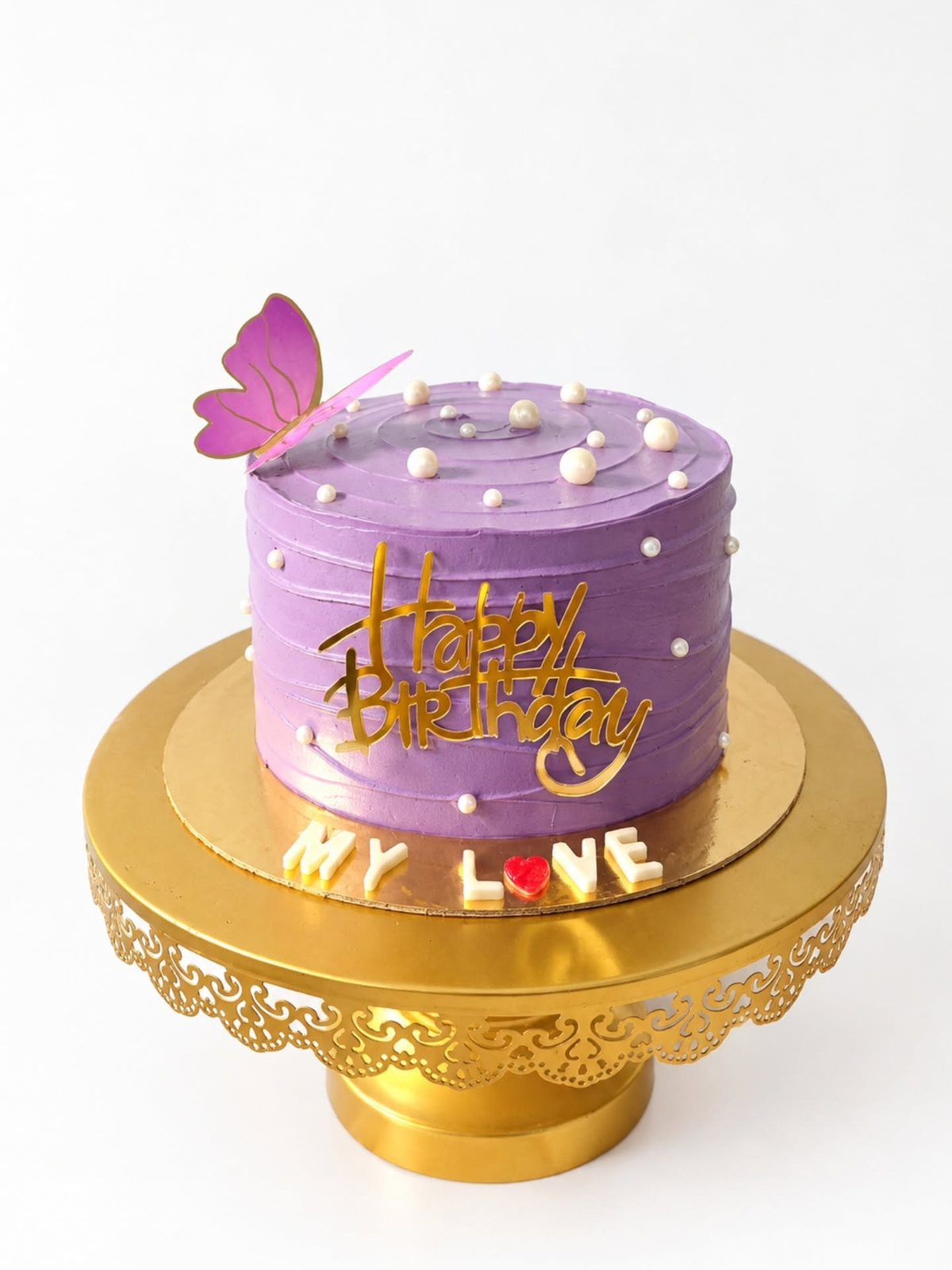 Lavender birthday cake with delicate piping on a gold stand