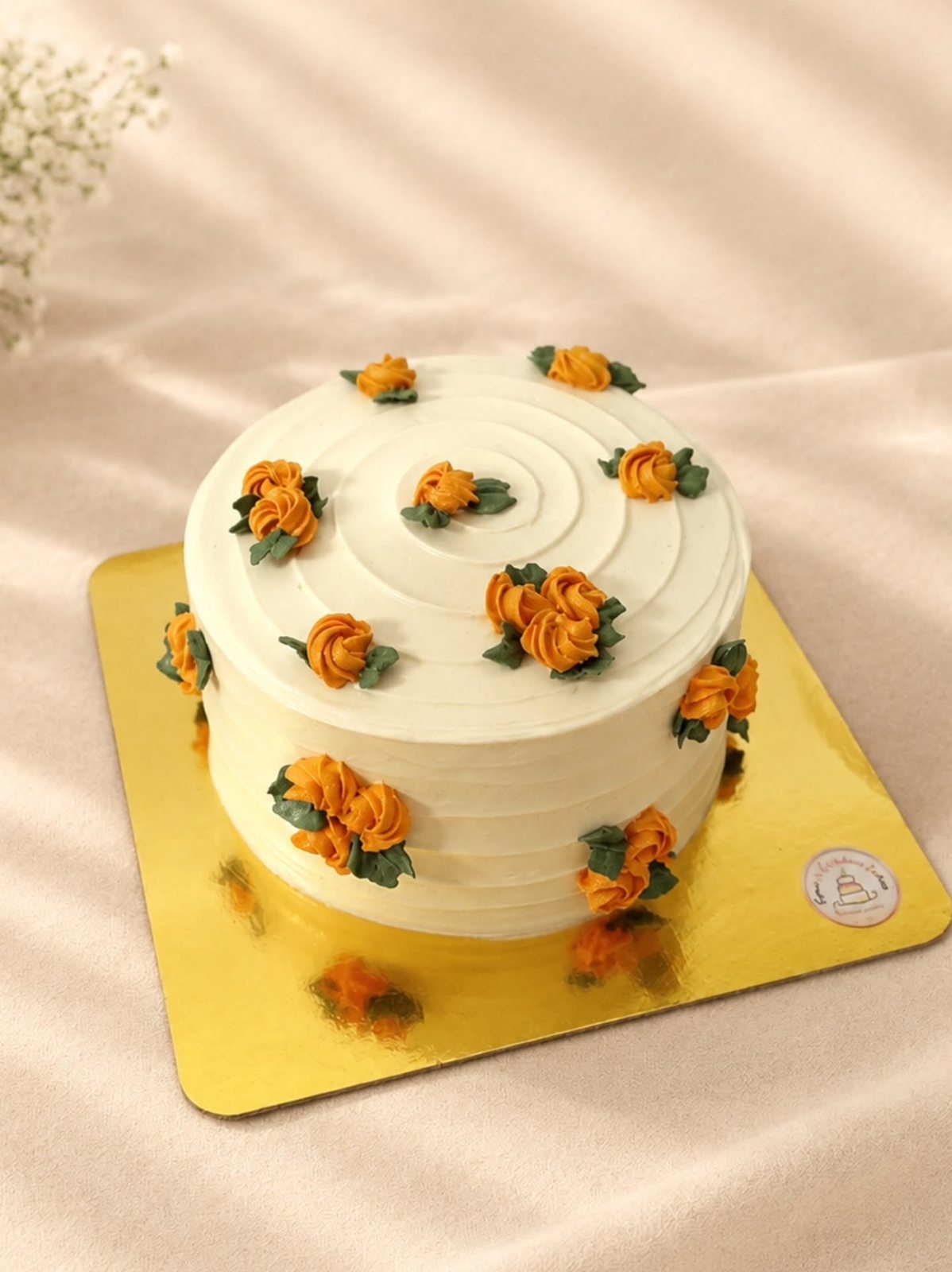 Cream cake decorated with tiny orange flowers